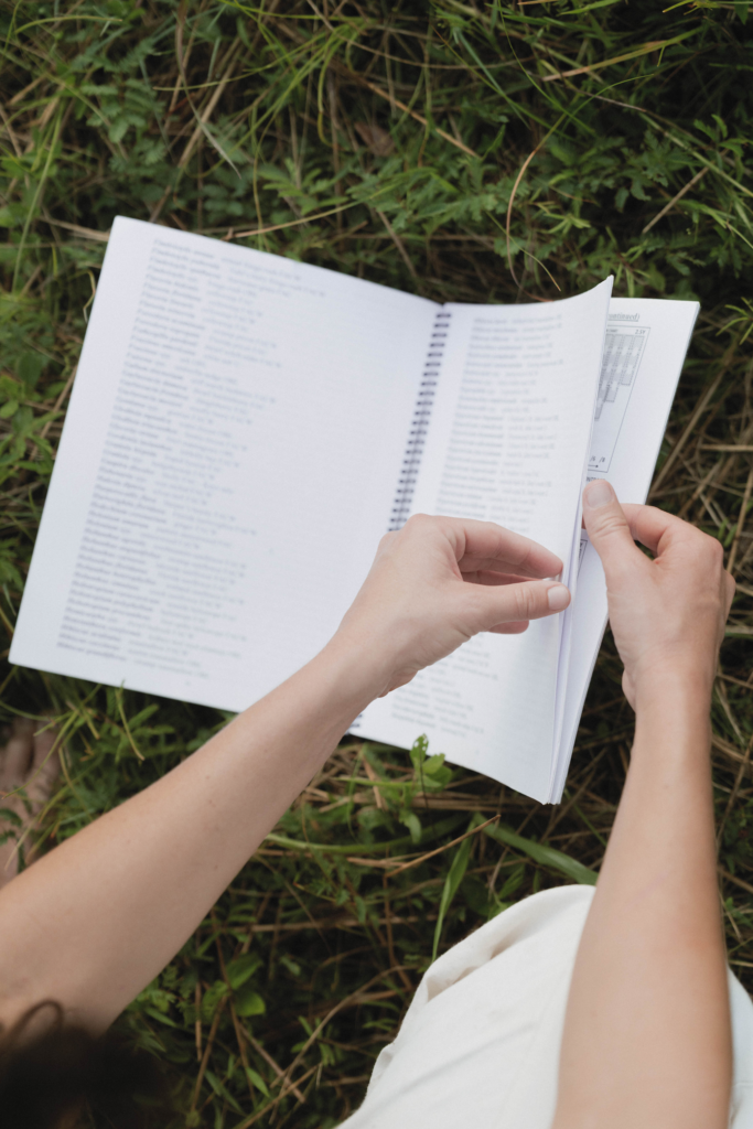Hands paging through a field reference guide during a site survey