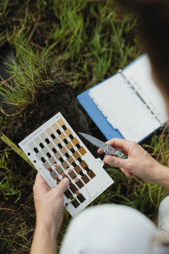 Comparing a soil sample to a Munsell soil color chart during a wetland delineation