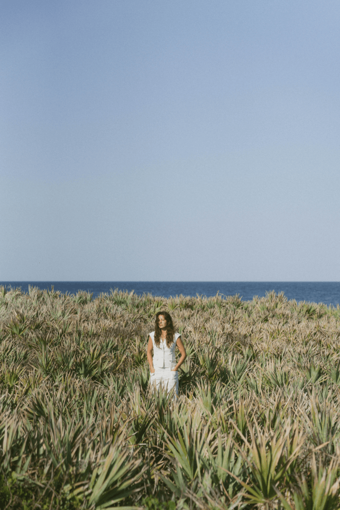 Savannah Parks standing in coastal dune vegetation near the Atlantic Ocean